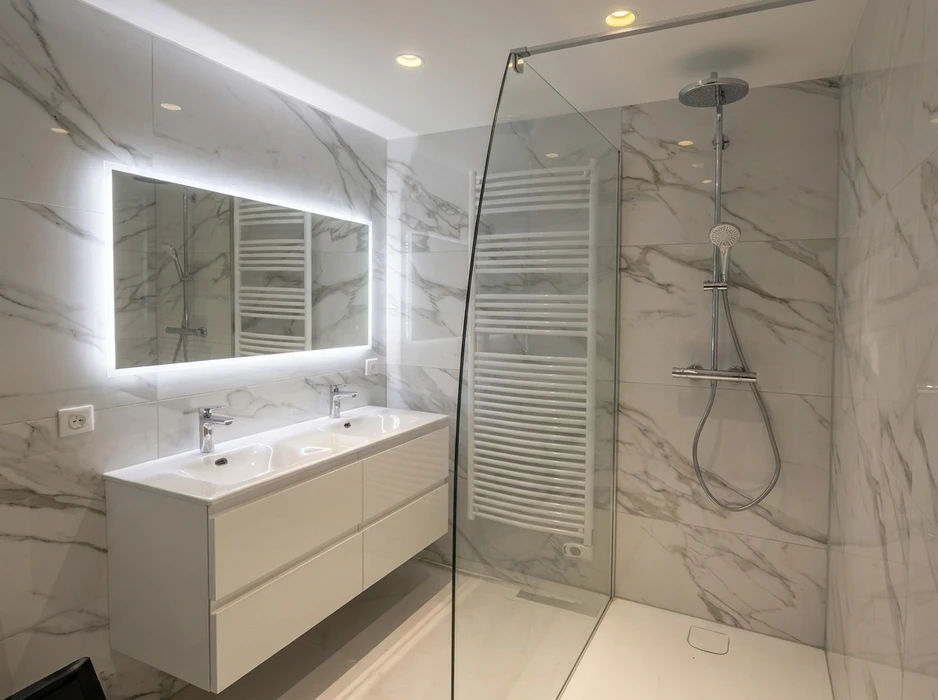 Salle de bain moderne avec double vasque encastrée sur meuble suspendu laqué blanc, miroir rétroéclairé LED, douche à l'italienne avec paroi en verre, robinetterie thermostatique chromée, colonne de douche avec pommeau de tête rond et douchette, sèche-serviettes à eau chaude, revêtement mural grand format imitation marbre Calacatta